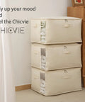 Three Heavy Duty Cotton Storage Bags With Clear Window And Sturdy Zipper 75L Collapsible Closet Organizer stacked in a bedroom.