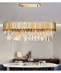 Contemporary Gold Finish K9 Crystal Drop Pendant Light With E14 Socket Straight Hanging Fixture For Kitchen Dining Room, luxurious design above dining table.