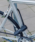 Granit 460 11.8 Inch Black U Lock With 12mm Round Shackle securing a bike to a silver frame on city pavement