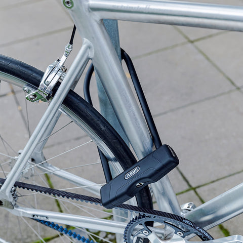 Granit 460 11.8 Inch Black U Lock With 12mm Round Shackle securing a bike to a silver frame on city pavement