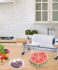 Stainless Steel Tabletop Stretch Film Dispenser With Film Slide Cutter surrounded by vegetables and fruit on a kitchen counter