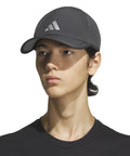 Person wearing Men's Superlite Cap With Perforated Panels For Maximum Airflow And Quick Dry Lightweight Moisture Wicking Workout Hat Grey