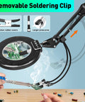12X Magnifying Glass With Light And Stand For Craft And DIY Projects All In One Super Handy Ultra Long 35 Inch Swing Arm Four Way Clamp LED Lighted Magnifier Lamp For Workbench Repair And Detailed Crafting, showing removable soldering clip in use on workbench.