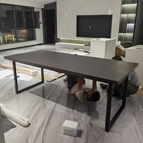 Damn Slick Matte Black Industrial Table Legs Built Tough With Solid Steel Frame For Heavy Duty Diy Coffee Or Dining Desk Projects That Hits Different On Modern Rustic Vibes For The Home, with a long black tabletop being assembled.