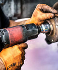 Person using a tool wearing Orange Nitrile Work Gloves Diamond Grip Eight Mil Thick Case Of Nine Hundred Extra Large Powder Free Latex Free Build.