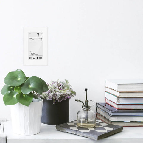 ET-72 Digital Programmable Thermostat For Floor Heating With Large LCD Display, mounted on wall above potted plants