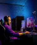 Gamer using Starport USB Laser Star Projector for Game Rooms and Bedrooms, vibrant starry sky effect enhancing gaming experience.