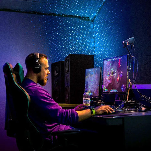 Gamer using Starport USB Laser Star Projector for Game Rooms and Bedrooms, vibrant starry sky effect enhancing gaming experience.