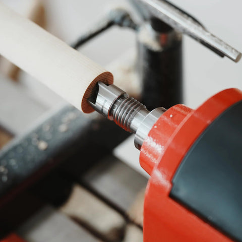 Close-up of BMWOOD 4-prong spring-loaded spur drive center, 2MT shank and 1-inch diameter, gripping light wood on a wood lathe.