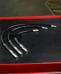 12 Inch Grease Gun Flex Hose With 4500 PSI Working Pressure Heavy Duty Coupler Included displayed on a workbench