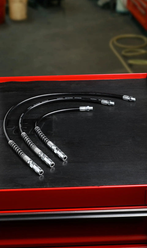 12 Inch Grease Gun Flex Hose With 4500 PSI Working Pressure Heavy Duty Coupler Included displayed on a workbench