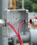 Heavy Duty 3/8 Inch MC Cable Connectors For 14 12 And 10 Gauge Wire connected to metal conduit box with red wires.