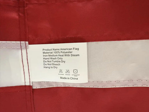 Close-up of USA Flag 2.5x4 Ft Pole Sleeve Banner Style With Embroidered Stars And Sewn Stripes Heavy Duty Durable Polyester tag details