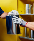 Person holding a metal can while wearing gloves near a Built Like A Tank 60 Gallon Flammable Safety Cabinet.