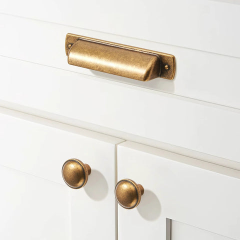 10 Pack Antique Brass Cup Pulls For Kitchen Cabinets And Furniture, 3 Inch Hole Center Drawer Pulls shown on white cabinet doors