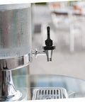 Hassle Free Universal Plastic Water Spigot And Dispenser Tap Fitting Standard Drink Coolers, black and chrome faucet on drink cooler.