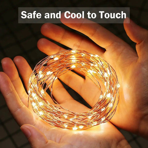Plug In Fairy Lights 33ft 100 LED Copper Wire String Lights Warm White Cozy Vibes held in hands, safe and cool to touch