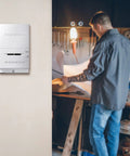 Manual Thermostat For Garage And Outdoor Buildings, Non Programmable White on wall with person working in garage.