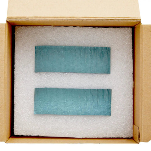 Blue rectangular objects inside cardboard box with padding for protection.