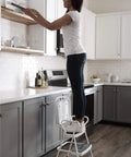 Person using Retro Style Chair And Flip Up Step Stool In White With Vinyl Seat And Steel Frame Dope Multi Purpose Counter Height Seat