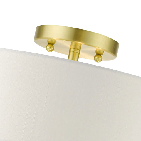 Close-up of satin brass mount on Meridian Collection 4-Light Semi-Flush Mount Ceiling Light With Off-White Fabric Shade.
