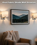 Edwarmlux Indoor Wall Sconces, Brushed Nickel, 1 Pack, E26 Bulbs Excluded, with oval fabric shade illuminating a cozy living room.