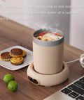 Keep Your Daily Brew Sizzling Hot This Smart Coffee Mug Warmer Uses An Ultra Smooth Metal Heating Base With Gravity Activated Control For Zero Fuss Desk Enjoyment with a heated cup and snacks on a desk.