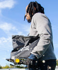 Man using Spyker 25lb Bag Spreader With Material Viewing Window And Easy Calibration System outdoors on a sunny day
