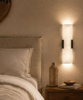 Tonabona 20" LED 18W 3000K Natural Alabaster Marble Farmhouse Bathroom 2 Pack Black Wall Sconce next to a bed.