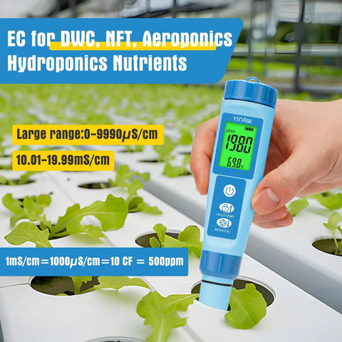 Hand holding 4 In 1 Digital pH Meter EC TDS And Temperature Tester for Hydroponics and Water Quality above plant tray.