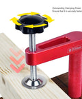 Close-up of red 2-Pack 20mm Aluminum Bench Dog Clamps With 600-Lb Hold-Down Power, clamped to wood, highlighting silicone pad.