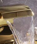 Close-up of gold bathroom sink faucet high arc waterfall spout with crystal knobs, part of 8 inch widespread solid brass design.