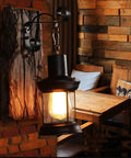 Top Shelf Rustic Wall Sconce Featuring Solid Wood Backplate And Vintage Industrial Metal Lantern Design Perfect For Chill Farmhouse Cafe Bar Or Bedroom Vibes Standard E26 E27 Socket Fits Up To Sixty Watt Bulbs, displayed in a cozy cafe setting.