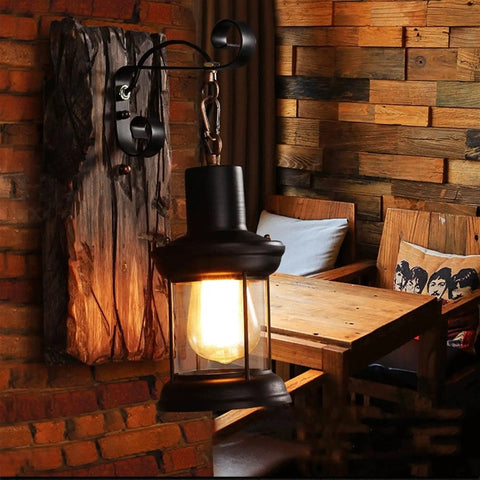 Top Shelf Rustic Wall Sconce Featuring Solid Wood Backplate And Vintage Industrial Metal Lantern Design Perfect For Chill Farmhouse Cafe Bar Or Bedroom Vibes Standard E26 E27 Socket Fits Up To Sixty Watt Bulbs, displayed in a cozy cafe setting.
