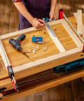Woodworker using 3/8 Inch Doweling Jig Kit With Drill Bit And Stop Collar, Dual Edge Stops for Easy Alignment on workbench.