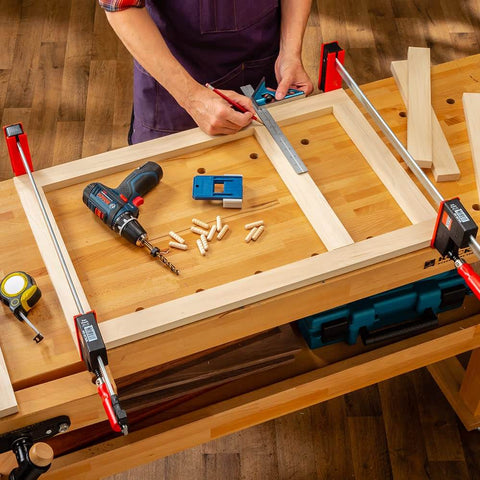 Woodworker using 3/8 Inch Doweling Jig Kit With Drill Bit And Stop Collar, Dual Edge Stops for Easy Alignment on workbench.