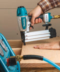 Renewed 18 Gauge Pneumatic Brad Nailer in use, driving nails into wood, lightweight aluminum body and magazine for durability.