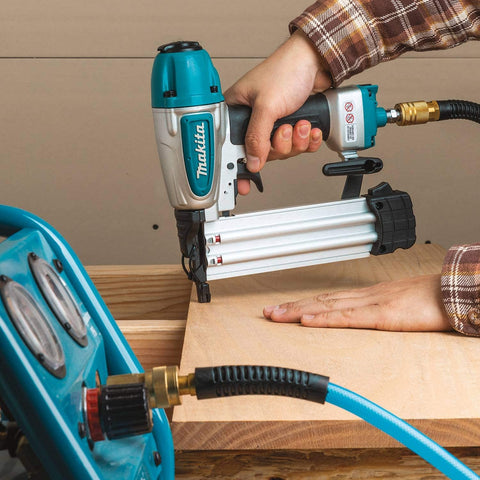 Renewed 18 Gauge Pneumatic Brad Nailer in use, driving nails into wood, lightweight aluminum body and magazine for durability.