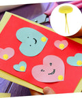 Card decorated with heart cutouts secured by yellow brads, featuring 500 Pieces Scrapbooking Paper Fasteners Brads Clip Set For Photos And Cards And Paper Crafts Durable Vintage Style Scrapbook Embellishments For Creative Journaling And Card Making.