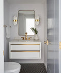 Mid Century Brass Wall Sconce With Glass Rods installed beside a bathroom vanity mirror
