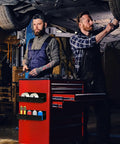 Mechanics using toolbox under car with six pack magnetic aerosol can holders with two sizes and four hooks attached to red cart.