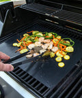 Heavy Duty Grill Mats Set Of 5 Nonstick BBQ Mats For Outdoor Grilling And Indoor Baking Reusable Easy To Clean Works On Gas Charcoal Electric Grills Keep Grates Clean And Flavorful With Extended Warranty in use on a gas grill with vegetables and shrimp.