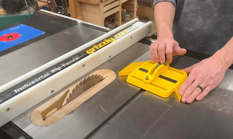 Adjustable Magnetic Featherboard For Table Saws And Router Tables Locks Stock Dead Tight Against Fence with hands positioning workpiece.