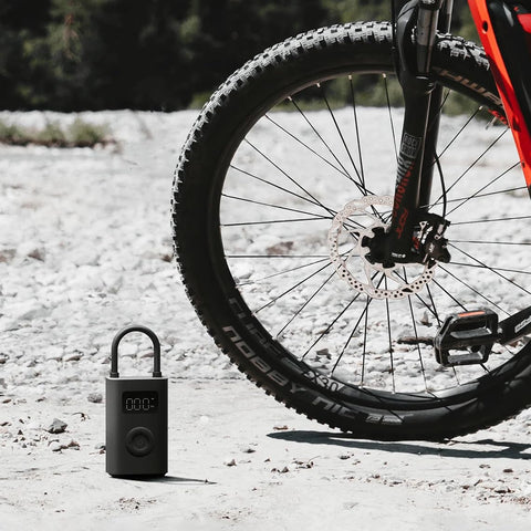Portable Electric Air Compressor 2 With 150 Psi, Fast Inflate For Cars, Trucks And Bikes shown next to a bicycle tire.