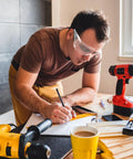Man wearing Six Pair Safety Glasses With Ventilated Louvered Frames And Wraparound Side Shields for lab projects, writing notes.