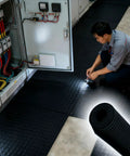Worker using Built Different Heavy Duty 35 KV Insulating Rubber Flooring Mat Anti Static Industrial Grade Safety Thick Cuttable Electric Shock Protection Pad Black.