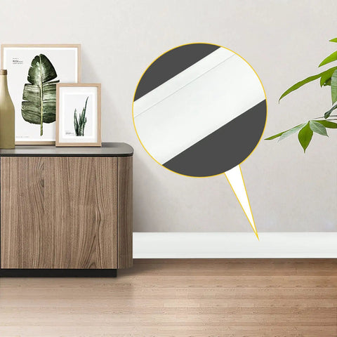 Super Easy Install Flexible Vinyl Baseboard Trim Molding Five Inches Wide And Forty Feet Long Cove Base With One Inch Crease Waterproof Tough Durable White Color For Your Walls shown installed in a living room.