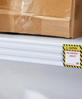 TopShelf Heavy Duty Pallet Rack Capacity Labels 100 Pack Featuring Durable 3X4 Inch Max Load Warning Stickers for a shelf with a box.