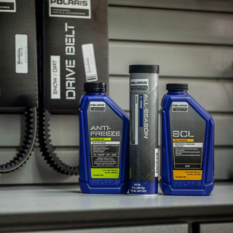 All Season Grease For Snowmobiles And Off Road Rigs Water Resistant Lubricant bottle displayed on shelf next to antifreeze and oil