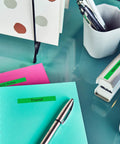 Slick Portable Monochrome Label Maker Featuring Qwerty Keyboard And Crisp Display Designed For Home Office Organization Includes Four Nifty Tape Rolls For Dead Simple Everyday Printing Tasks on a desk with labeled notebooks.